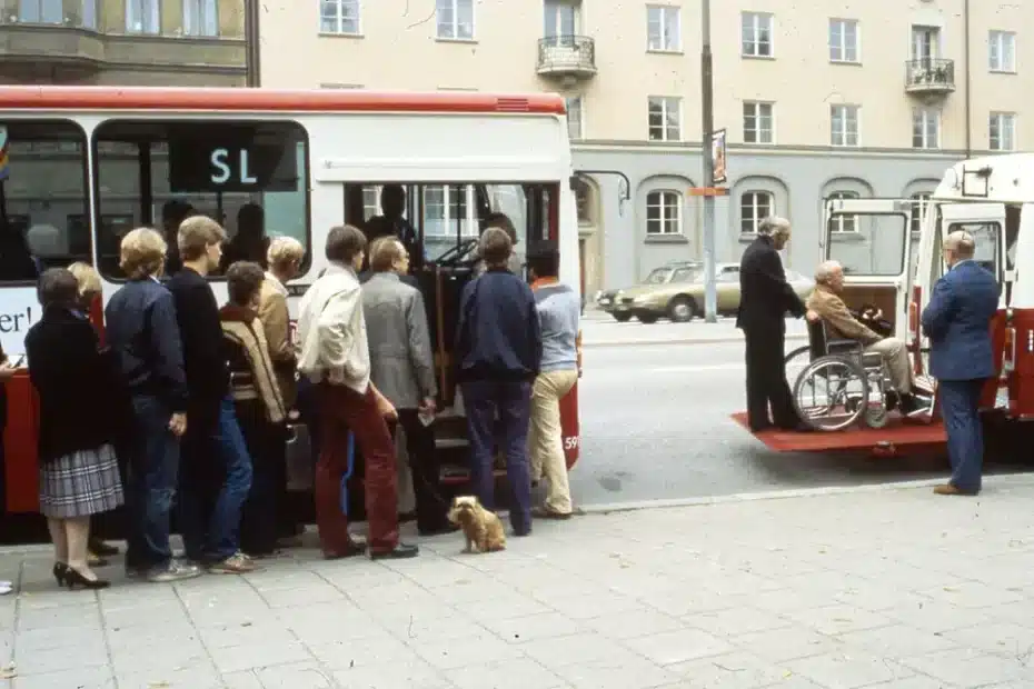 På- och avstigning i färdtjänstbuss. Stadsmiljö 1970- eller 80-tal.