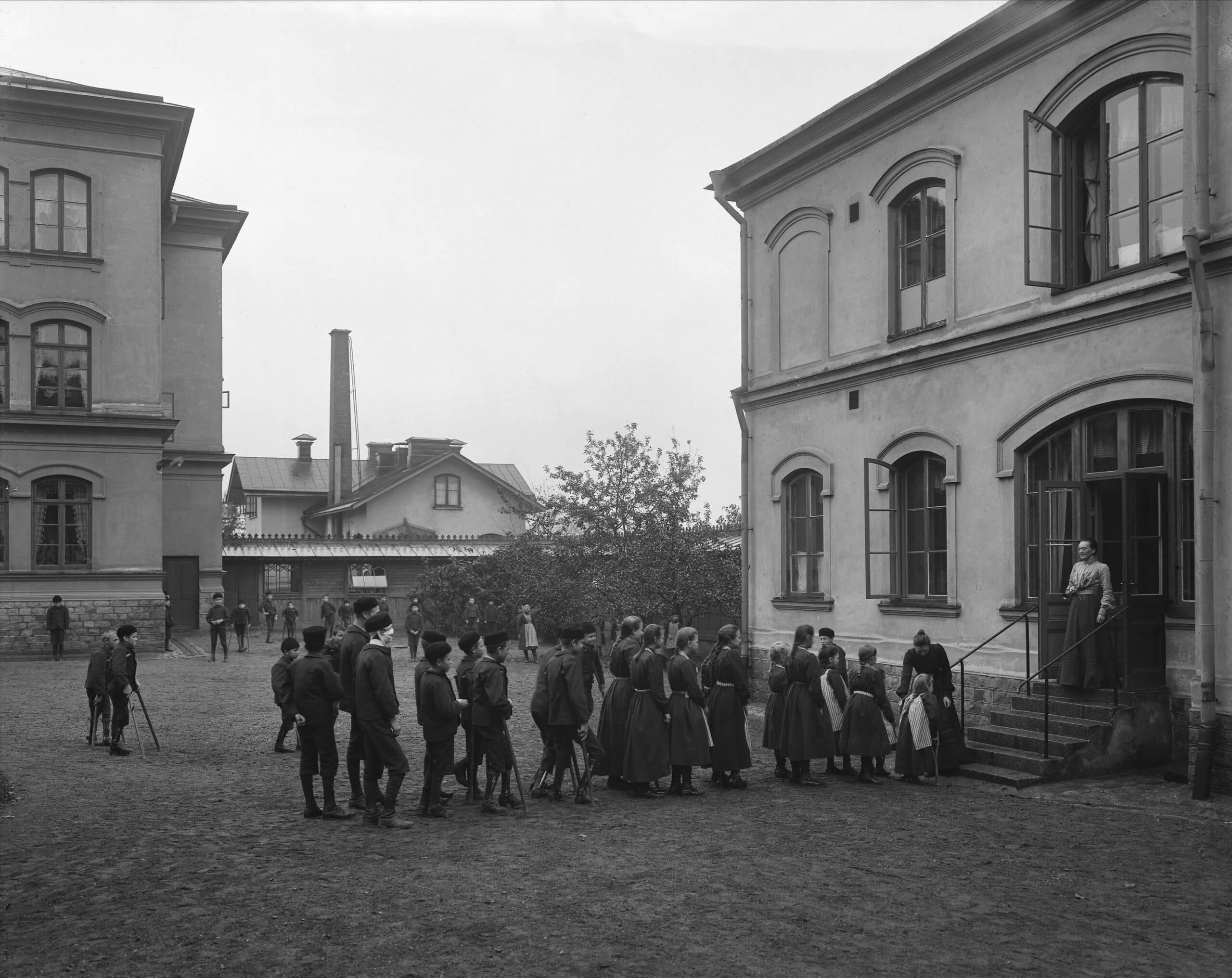 Barn står med kryckor och proteser uppställda nedanför utanför Eugeniahemmet. De ser ut att vara på väg in.